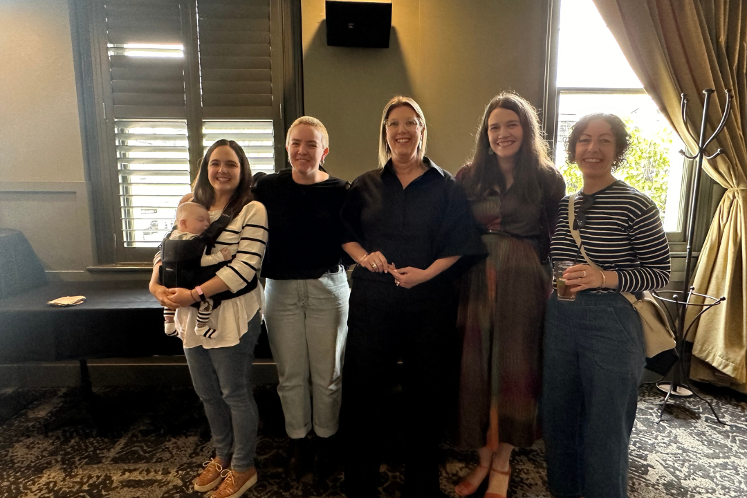 A group of 5 carers and staff smiling at the camera.