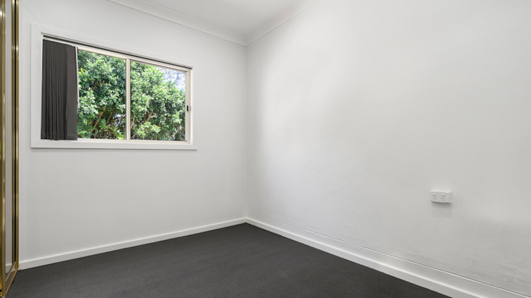 Empty bedroom with built-in wardrobe.