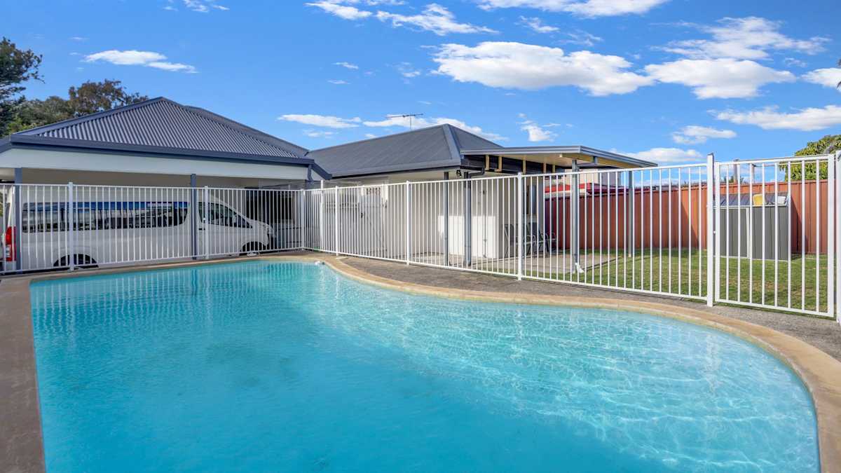 Outdoor fenced pool with shallow stairs for easy access.