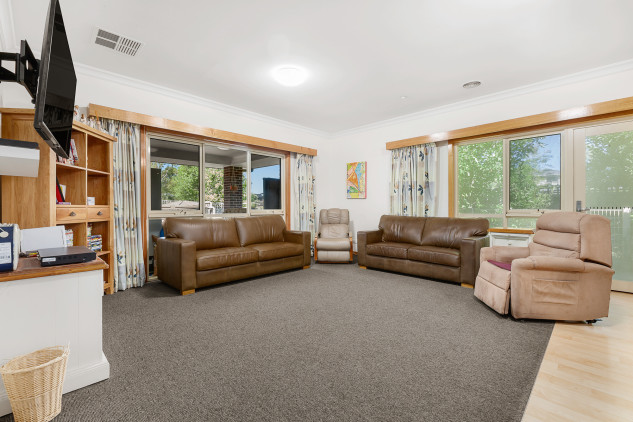 open plan loungeroom, with sofas and reclining chairs.