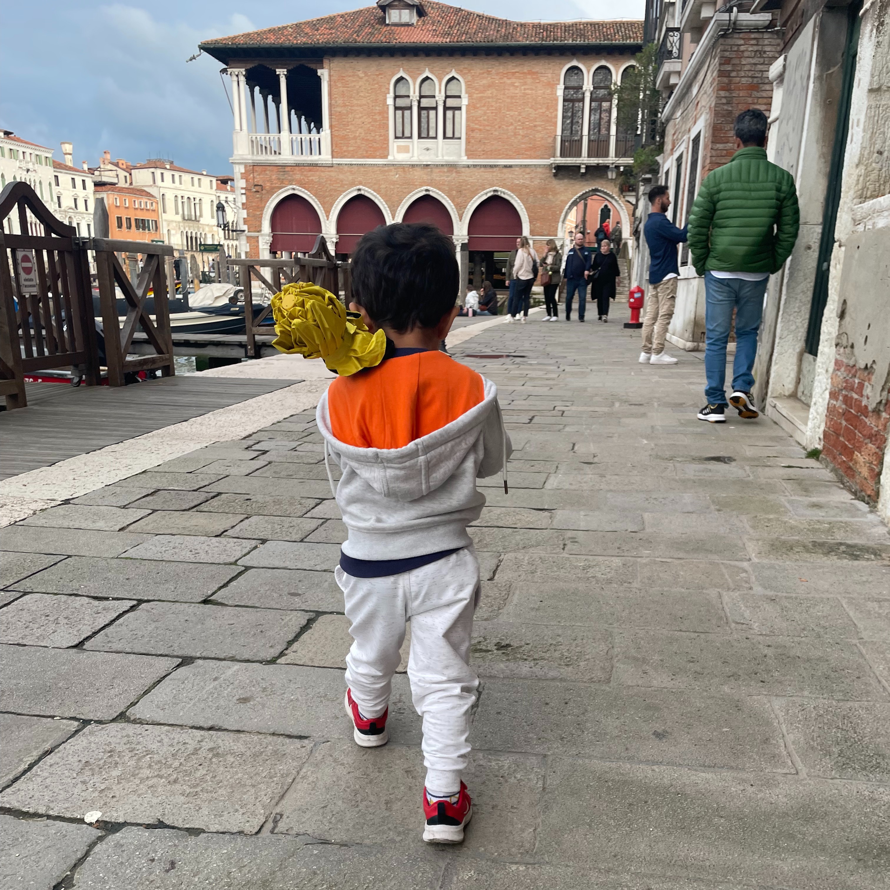 Two adults making a little boy hold an umbrella...so what if the boy asked for it himself...