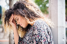 Žena dotýkající se hlavy kvůli bolestem a menstruačním křečím