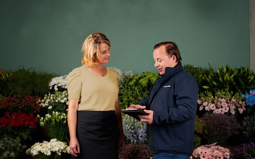 Un fioraio riceve spiegazioni sul negozio online per grossisti di fiori
