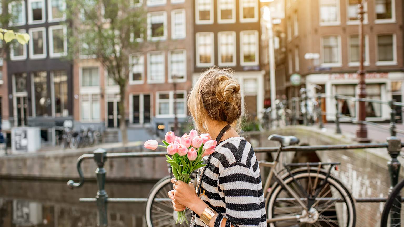 netherlands-amsterdam-canal-woman-flowers-swiper-hero-gallery
