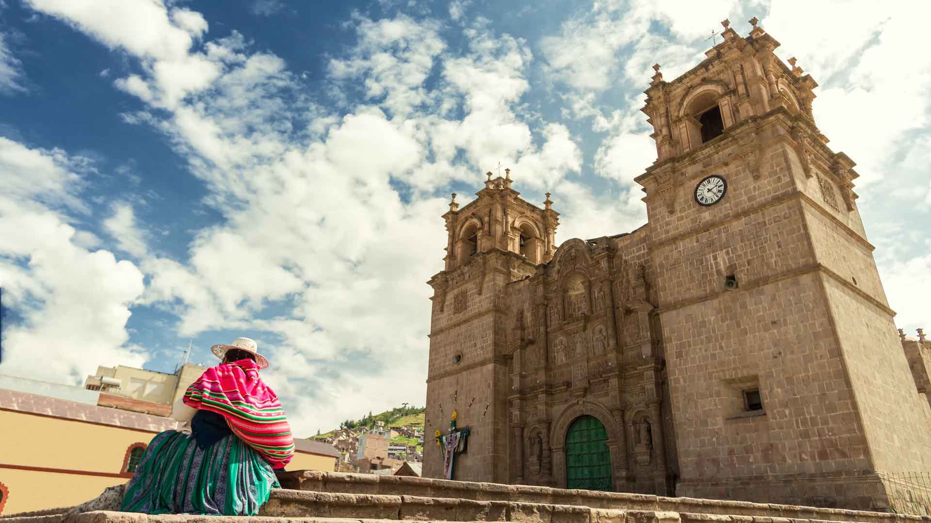 Woman-with-keperina-bag-on-her-back-sitting-on-the-steps-of-the-Cathedral-of-Puno-Peru