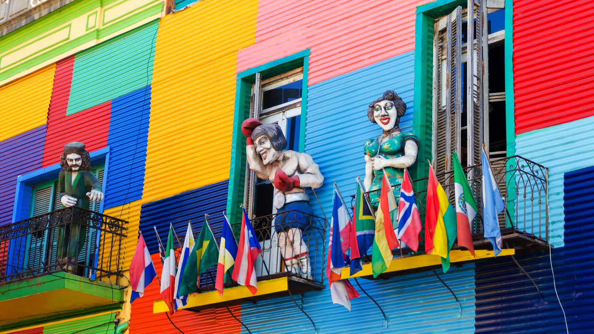 a-colorful-building-in-la-boca-neighborhood-of-buenos-aires-with-statues-and-flags