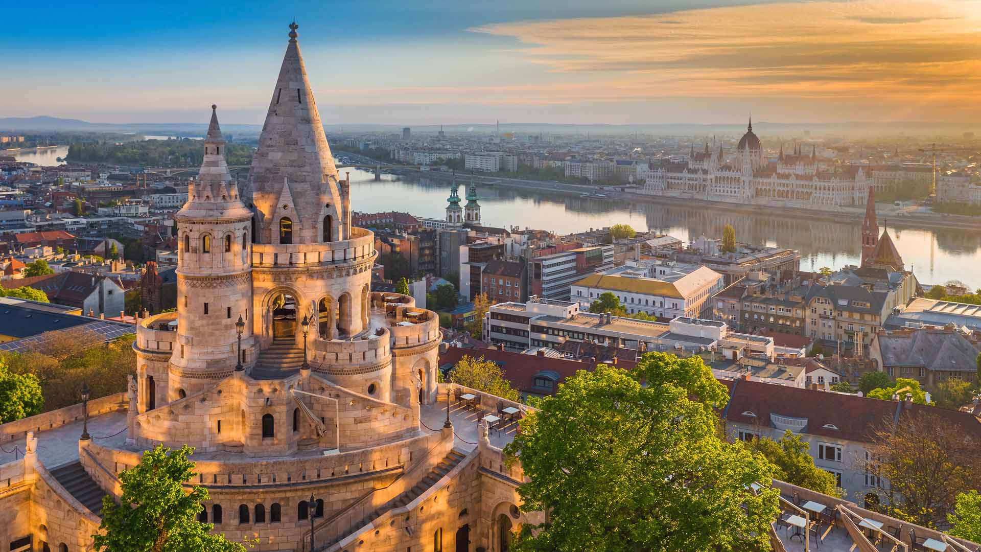 Budapest Hungary - Beautiful golden summer sunrise with the tower of Fisherman-s Bastion and green trees. Parliament of Hun