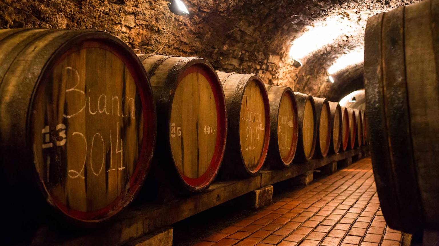 traditional-wooden-barrels-with-wine-in-a-vault-lined-up-in-cool-and-dark-cellar-in-Italy-Porto-Portugal