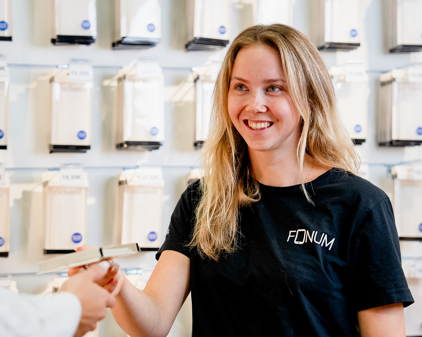 Fonumin työntekijä ojentamassa suojakuorta asiakkaalle