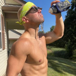 a man drinks water with headband