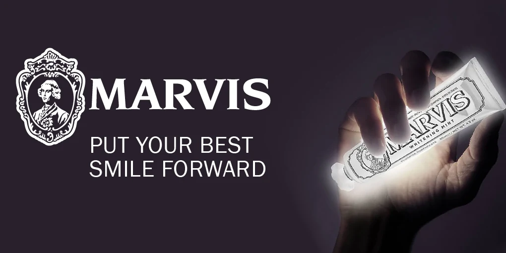 Marvis logo and toothpaste tube glowing in hand against dark background, with slogan "Put Your Best Smile Forward"