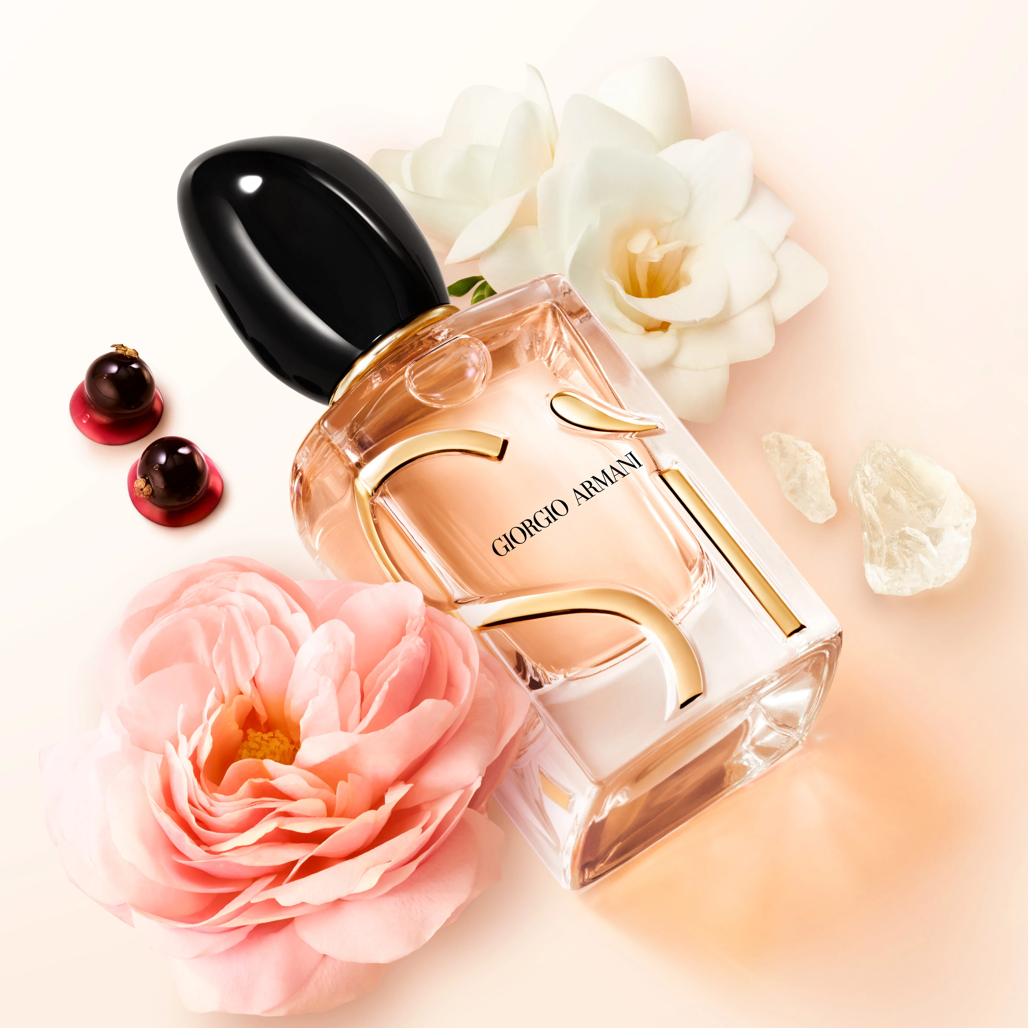 Giorgio Armani Si perfume bottle with pink and white roses and red berries against a soft pink background