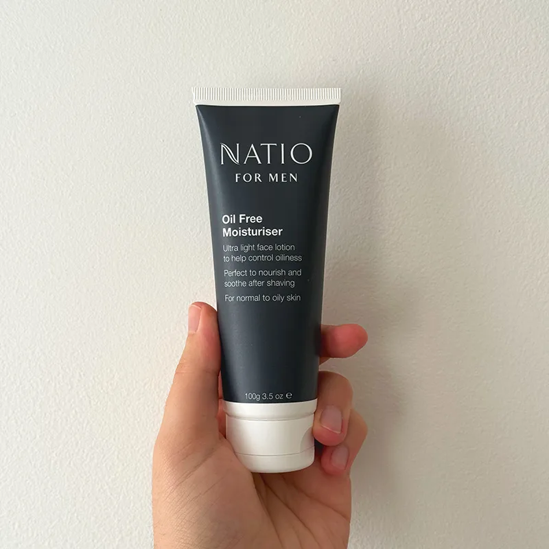 Hand holding a Natio Men's Plus moisturiser