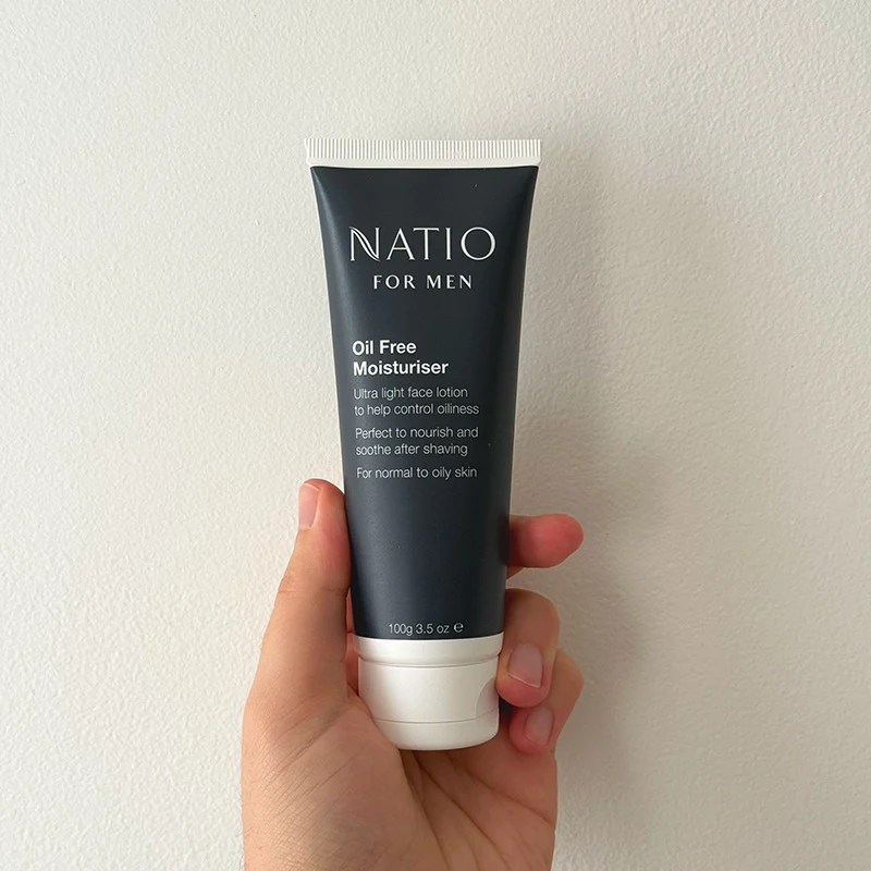 Hand holding a Natio Men's Plus moisturiser