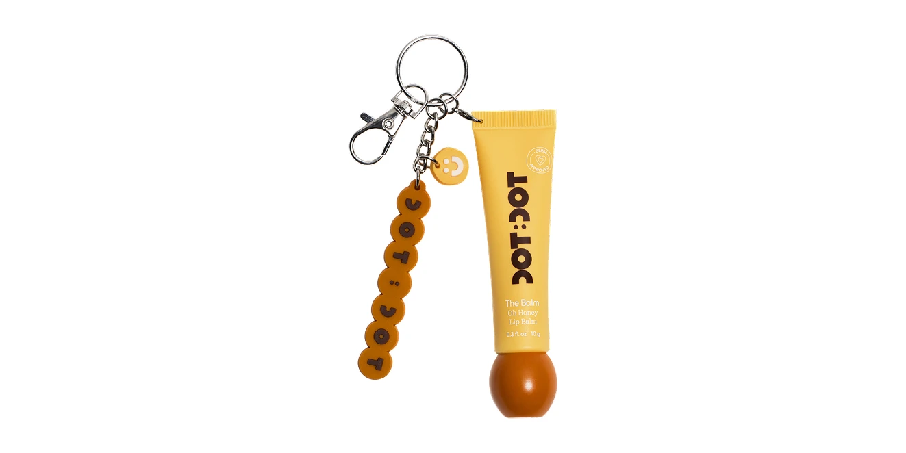 Yellow DOT:DOT Oh Honey Lip Balm tube on a keychain with branded letter bead charm and silver clasp.