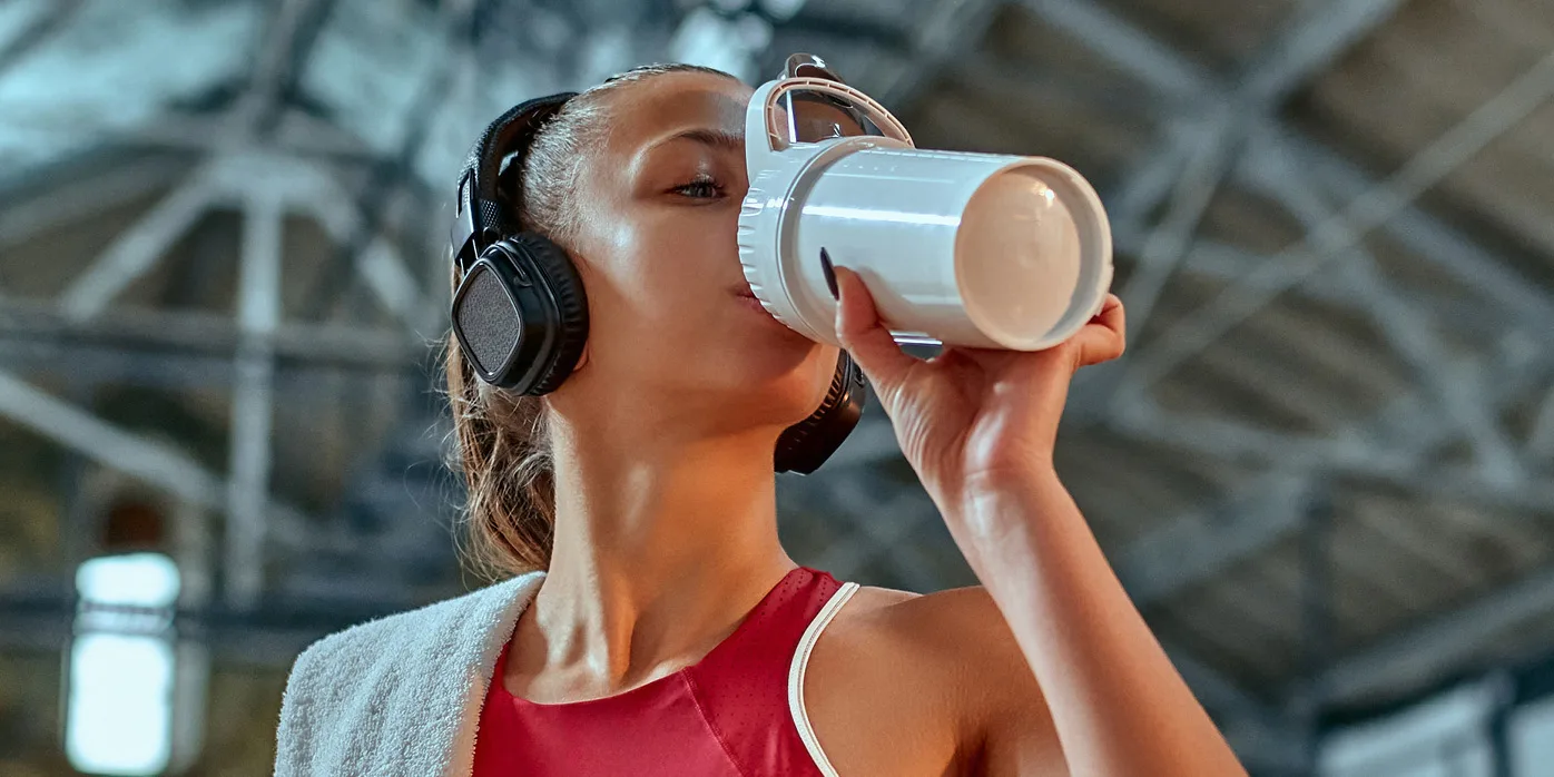 A woman exercising and drinking out of a bottle