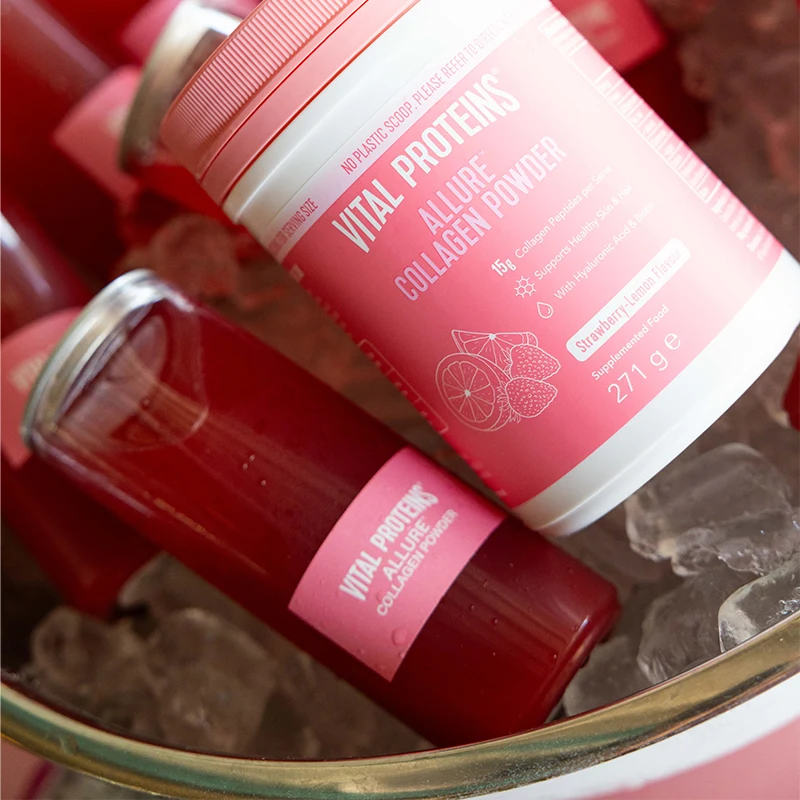 Pink protein powder container with "Vital Proteins" collagen supplement label, resting on ice in a glass bowl.