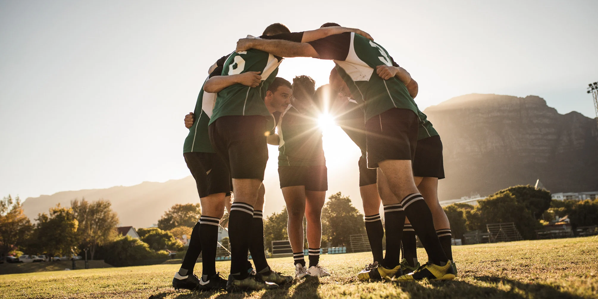 Sports players huddling together