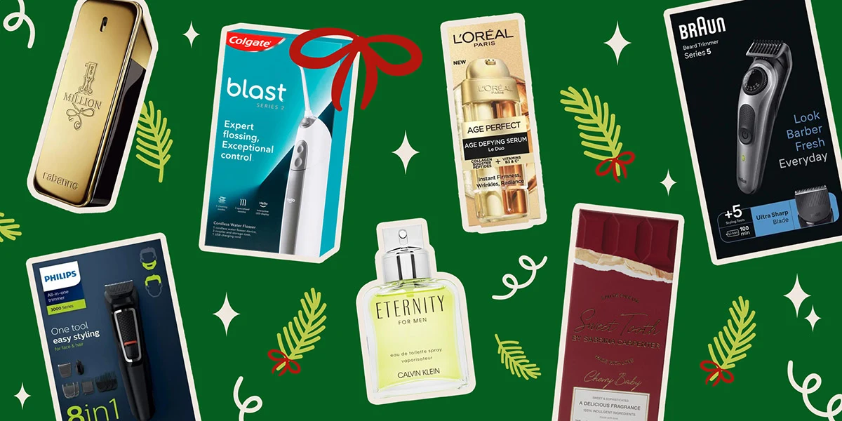 Holiday gift products on green background with festive decorations: grooming items, perfume, and beauty products from premium brands
