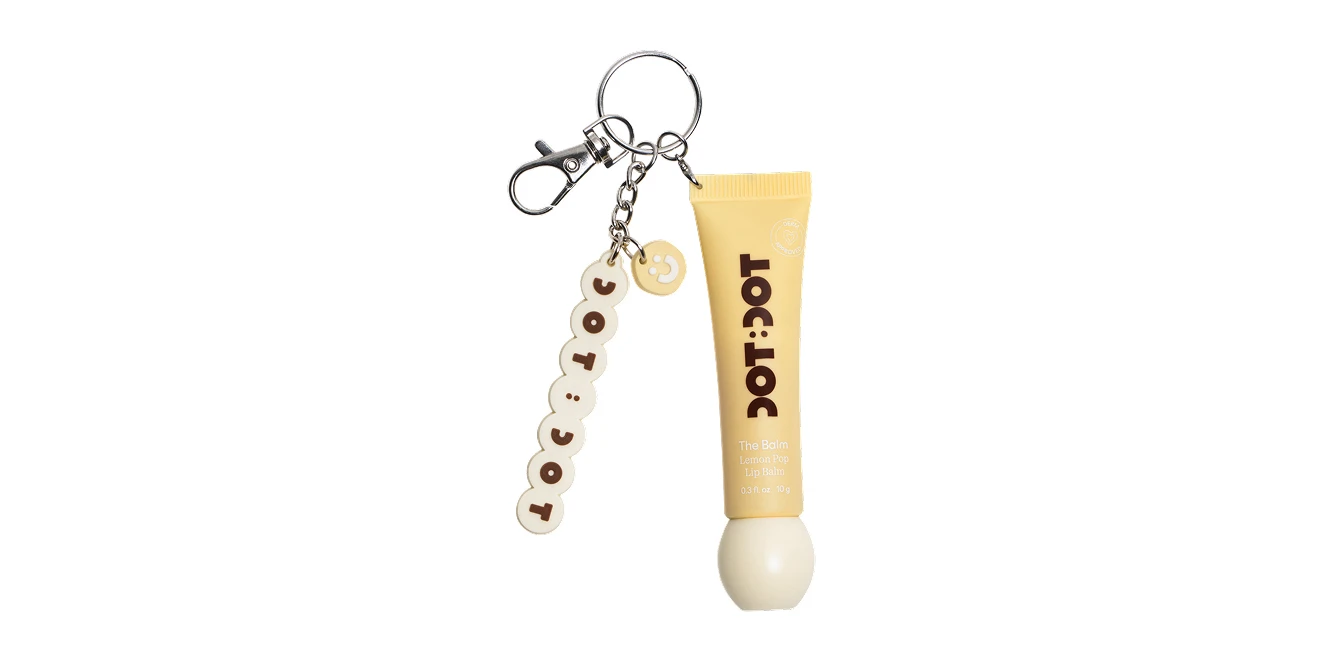 DOT:DOT The Balm Lemon Pop Lip Balm keychain with yellow tube, bead charm spelling DOT:DOT, and silver clasp on white background.
