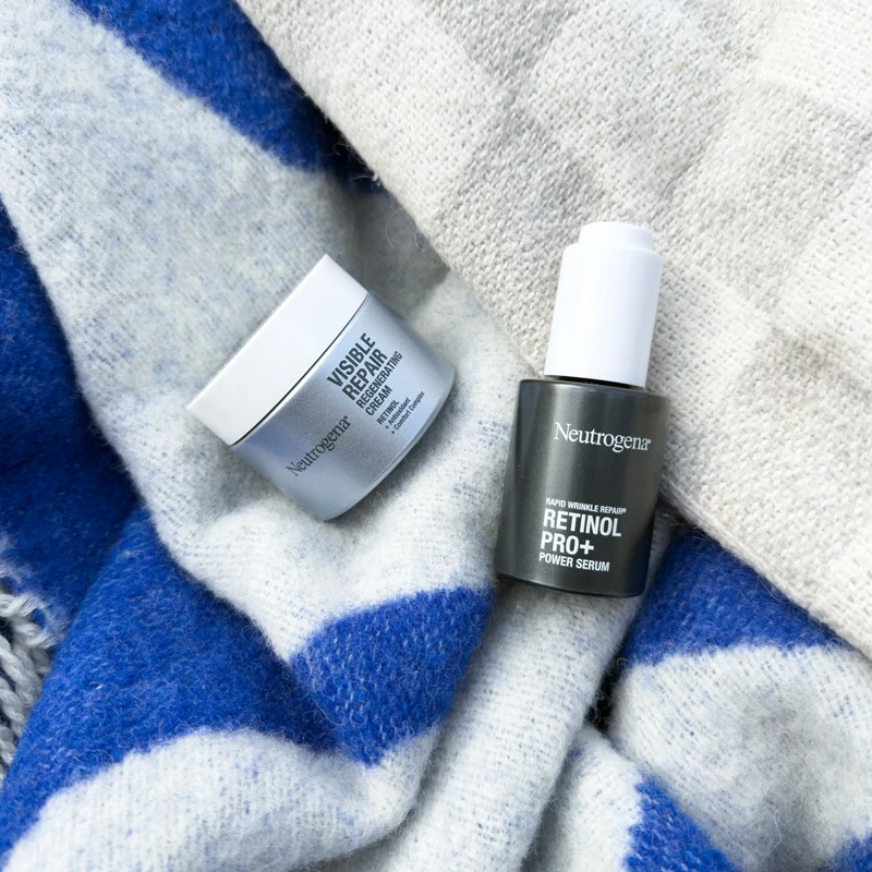 Neutrogena Visible Repair Regenerating Cream and Retinol Pro+ Power Serum on a blue and white knit blanket.