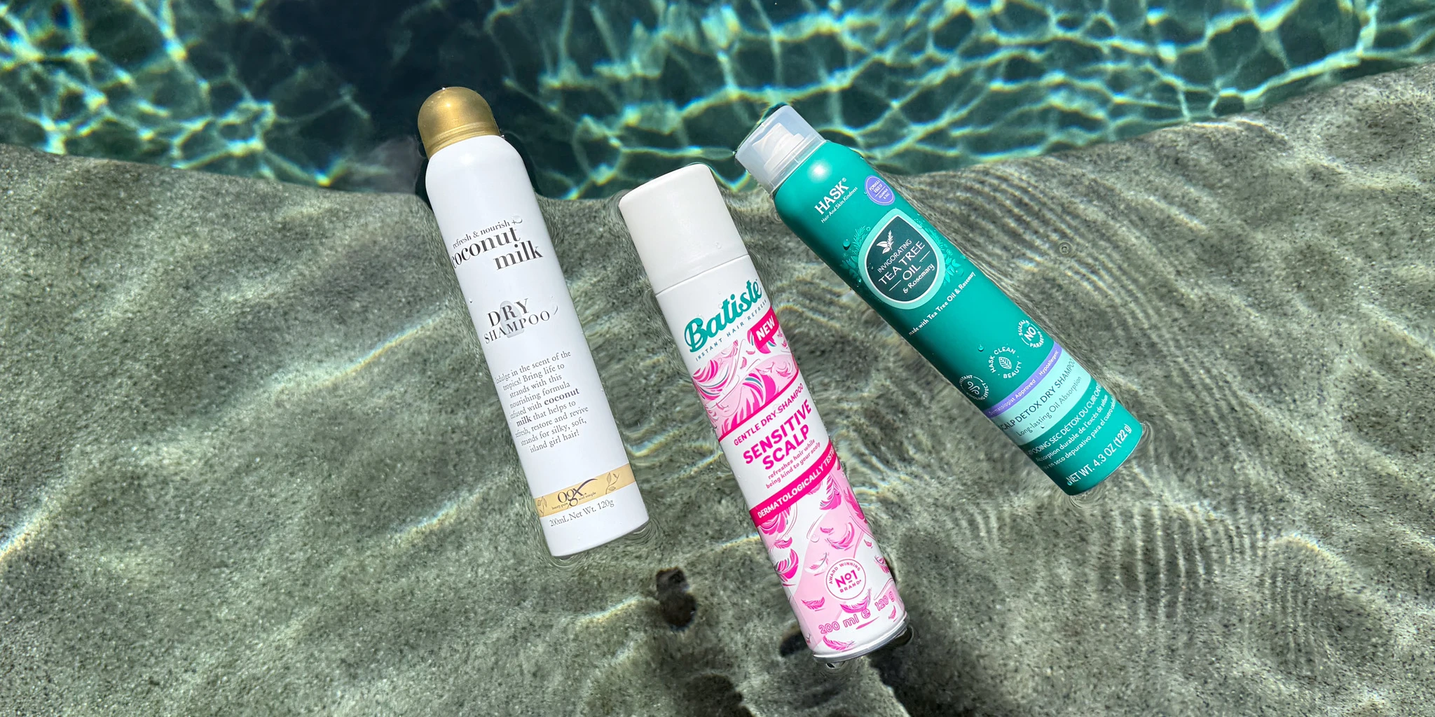 Three dry shampoo bottles lying on pool steps underwater, with rippling water patterns visible in the background.