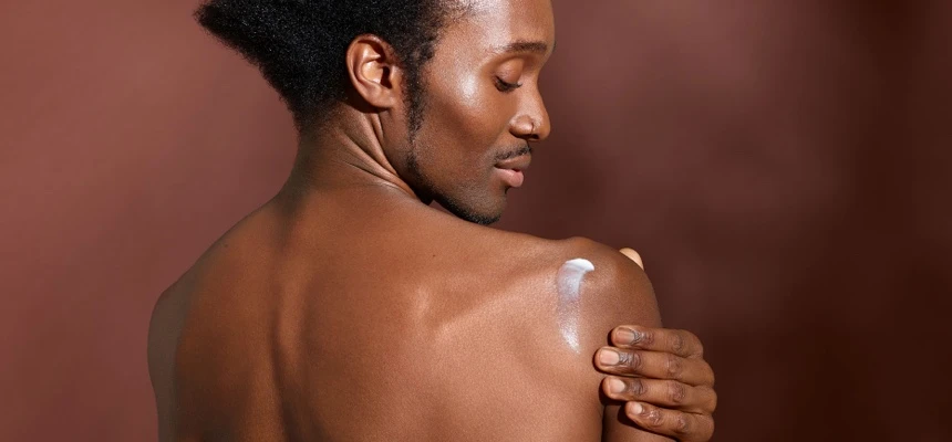 Man rubbing cream into his shoulder