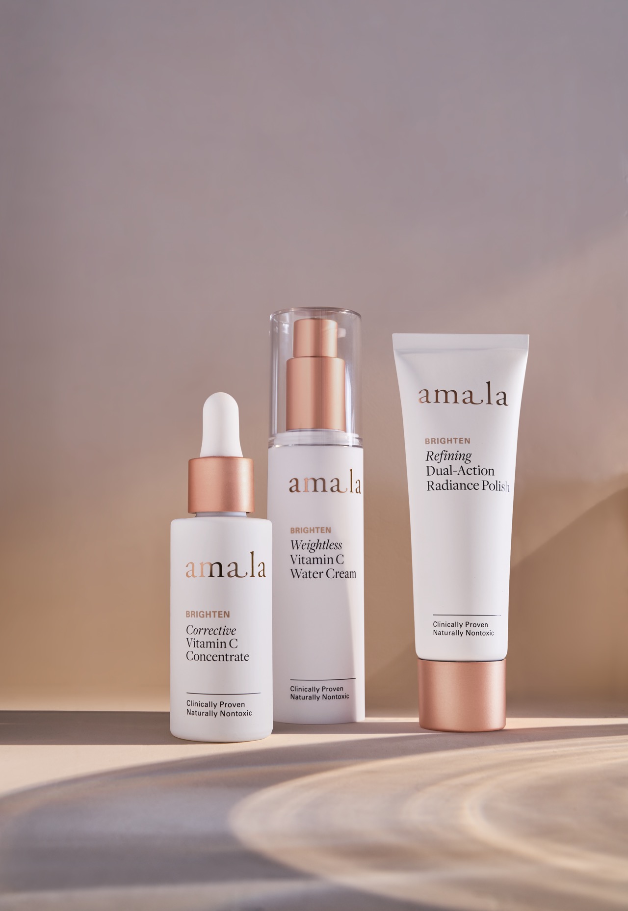 Three Amala products. Corrective Vitamin C concentrate, Weightless Vitamin C water cream, and Refining Dual-Action Radiance Polish