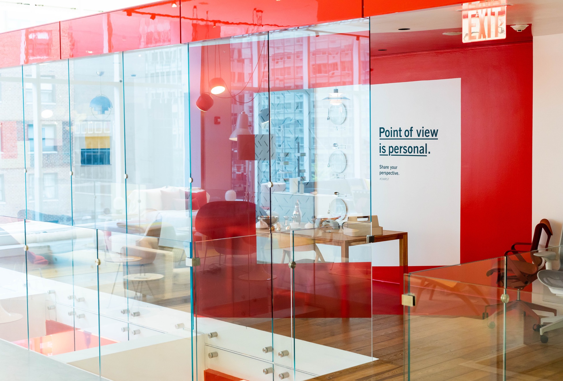 DWR East 57th St store interior with super graphics creating a red frame. Room filled with furniture. Graphic on wall reads Point of View is Personal