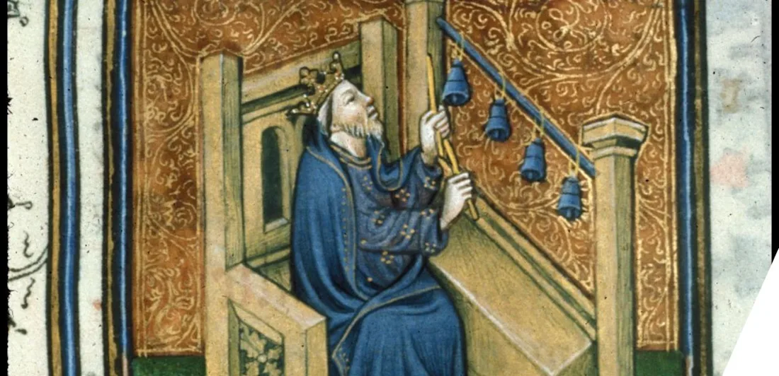 Manuscript illustration of a crowned man striking some small bells