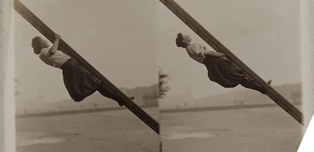 A woman gripping the underside of a ladder at a 45 degree angle