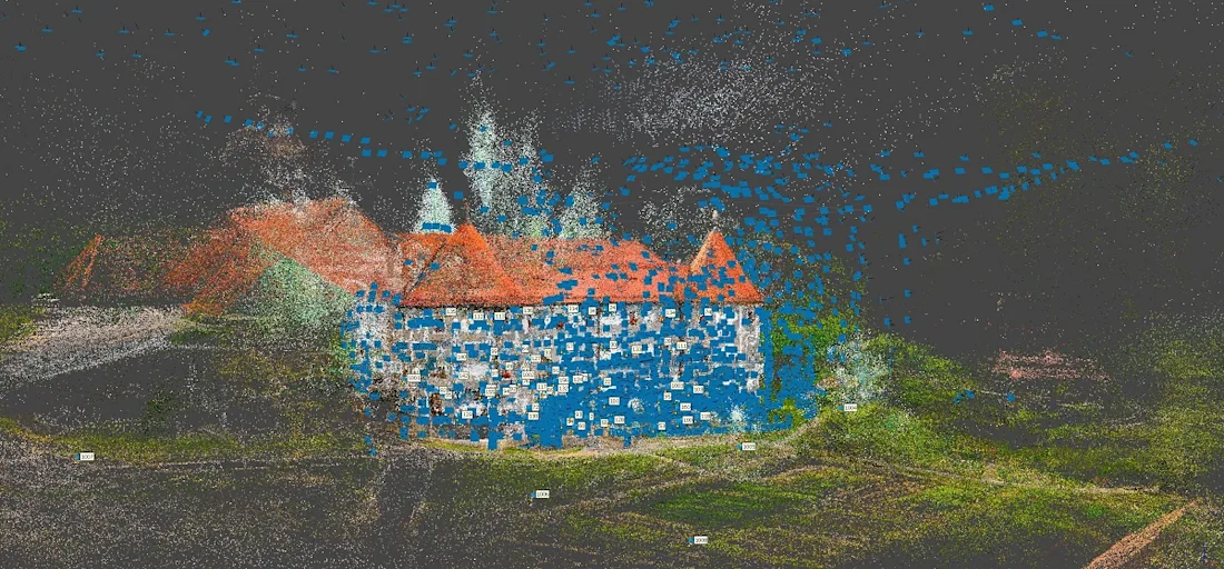 A large white building with curved walls and a red roof, overlaid with many blue dots