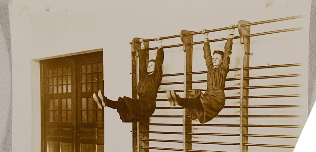 Two people doing exercises on wall bars