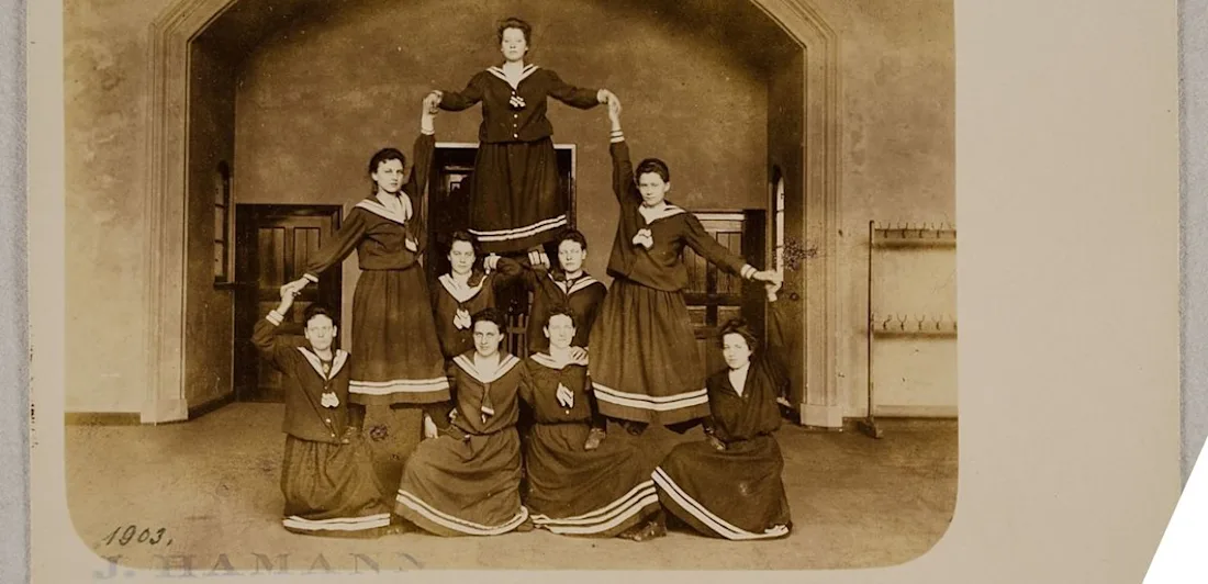 Gymnasts wearing dresses forming a human pyramid