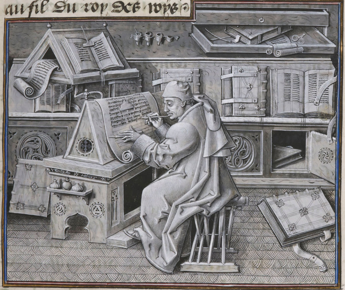 Scribe working surrounded by books