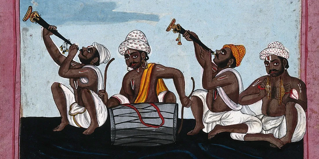 Four seated Indian musicians play instruments