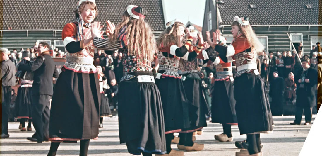 A group in traditional dress dance on ice