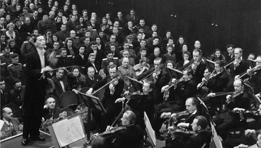 black and white photograph, conductor leading a concert orchestra