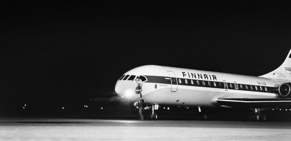 black and white photograph, a plane at night on an airport runway.