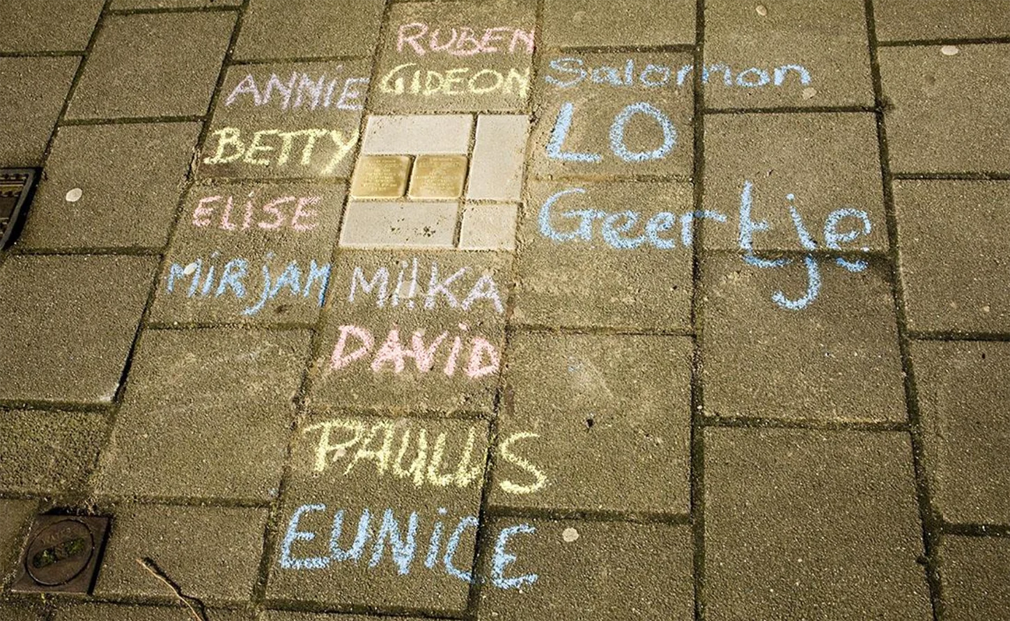 Farbfoto, Namen in Kreide um zwei Stolpersteine geschrieben.