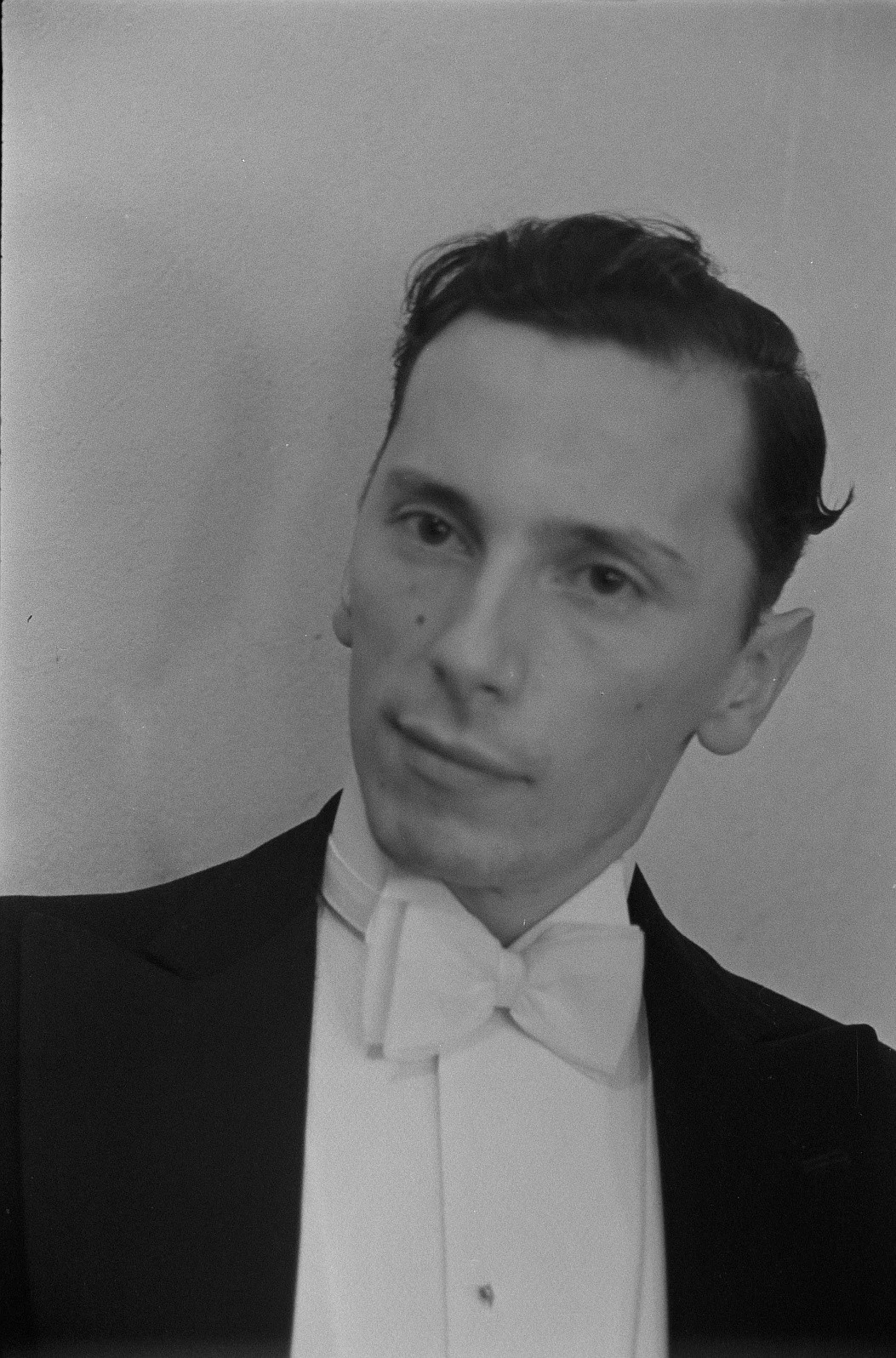 black and white photograph portrait of Andrzej Panufnik, a young man wearing a suit and a bow-tie