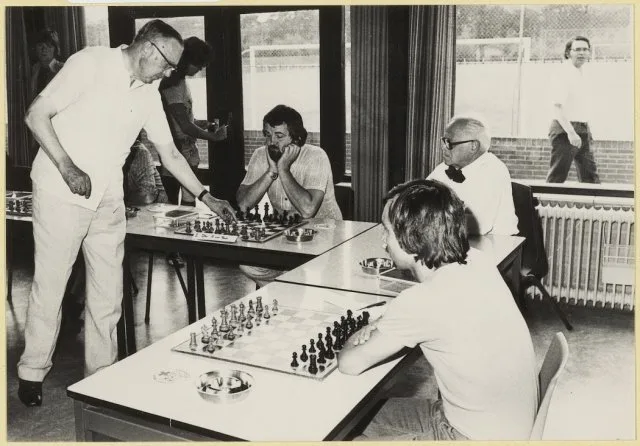 black and white photograph of Max Euwe playing chess against two opponents