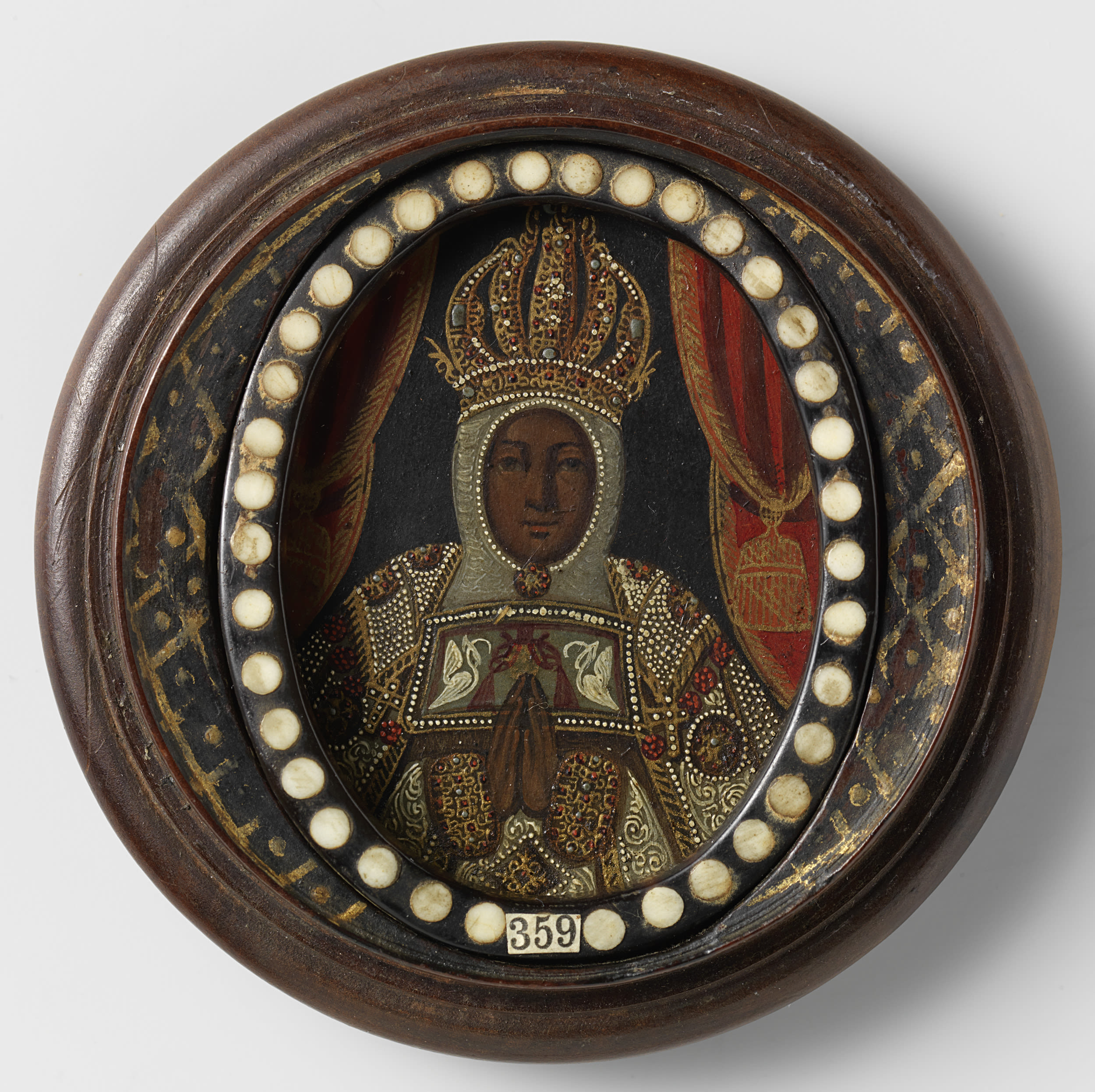 A Black Madonna bust, on the inside of a round wooden box. With an inscription on the inside of the lid.