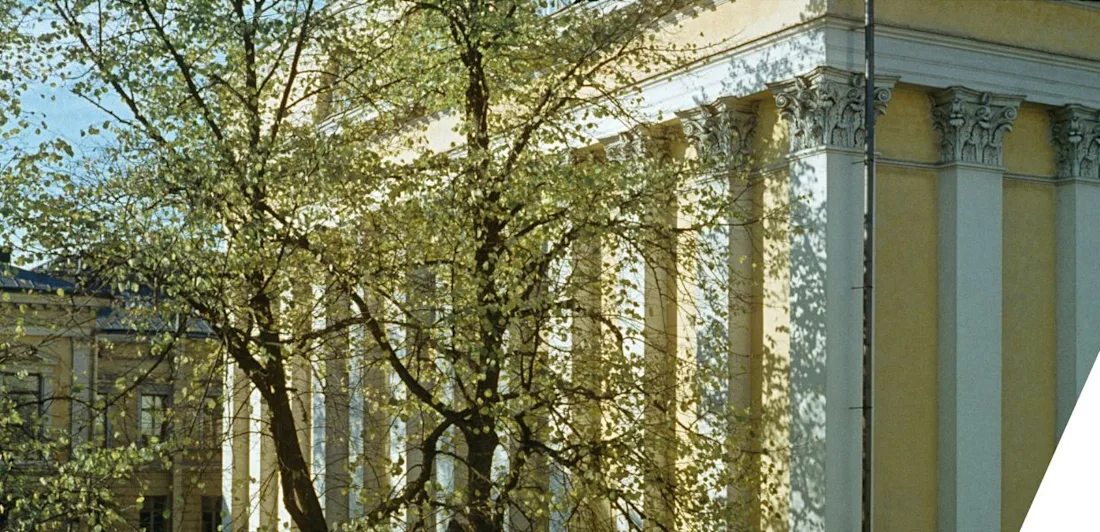Tall Corinthian columns line the sunlit façade of a neoclassical building