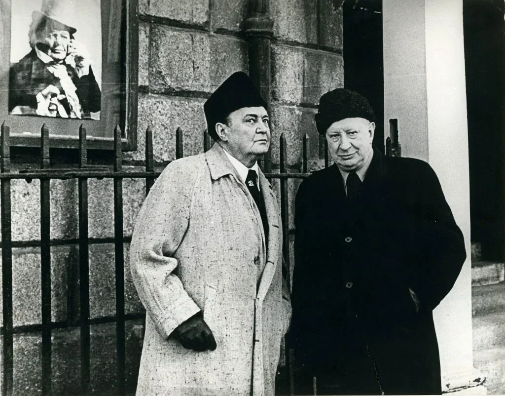 Black and white portrait photograph of Micheál Mac Liammóir & Hilton Edwards, who wear heavy coats and winter hats.