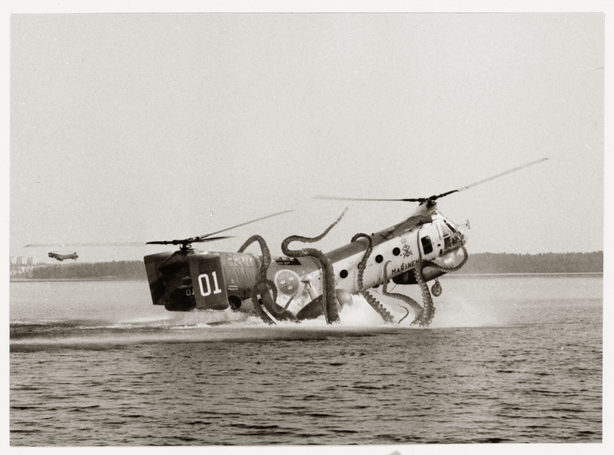 A helicopter being dragged into the sea by the tentacles of a large octopus-like creature