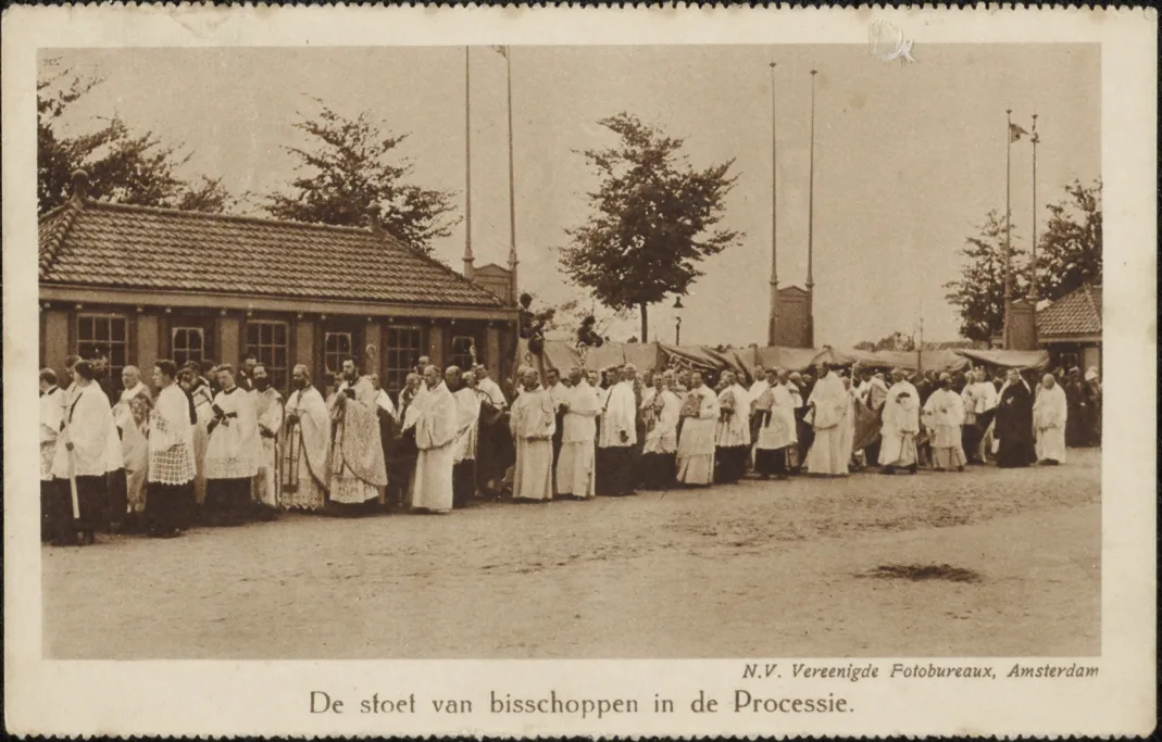Black and white postcard of a row of priests