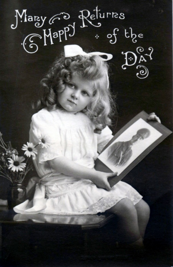 black and white photograph, a young girl holds a photograph of a soldier