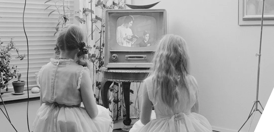 Two children sat on the floor watching television