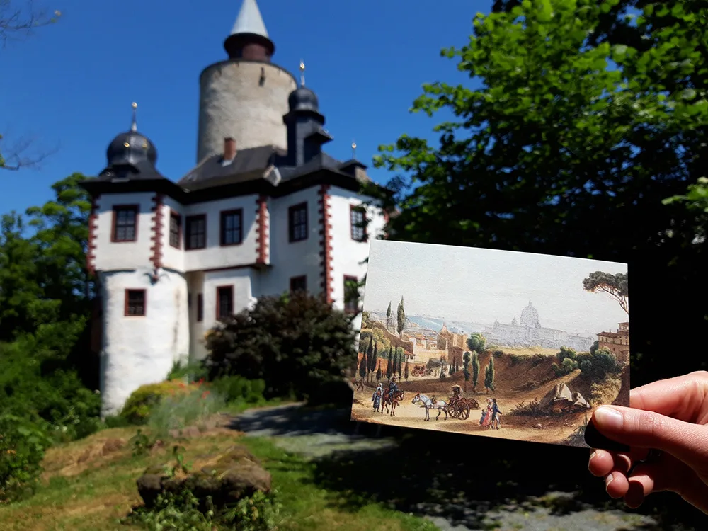 colour photograph of a postcard being held in front of a castle